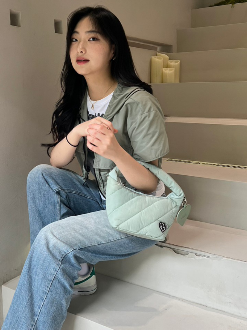Girl carrying light pastel green cushion bag